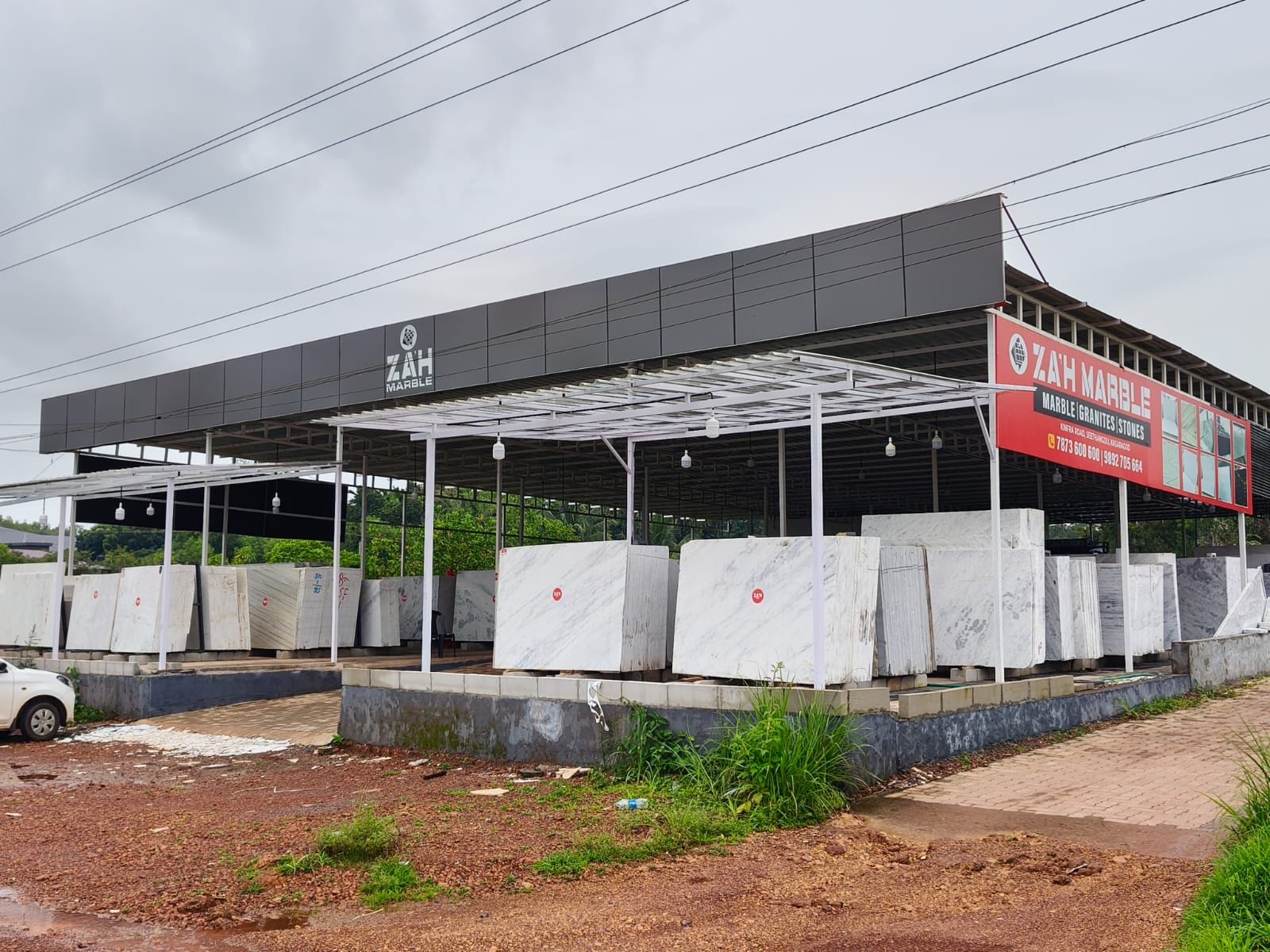 The red ZAH Marble signboard at the entrance on KINFRA Road